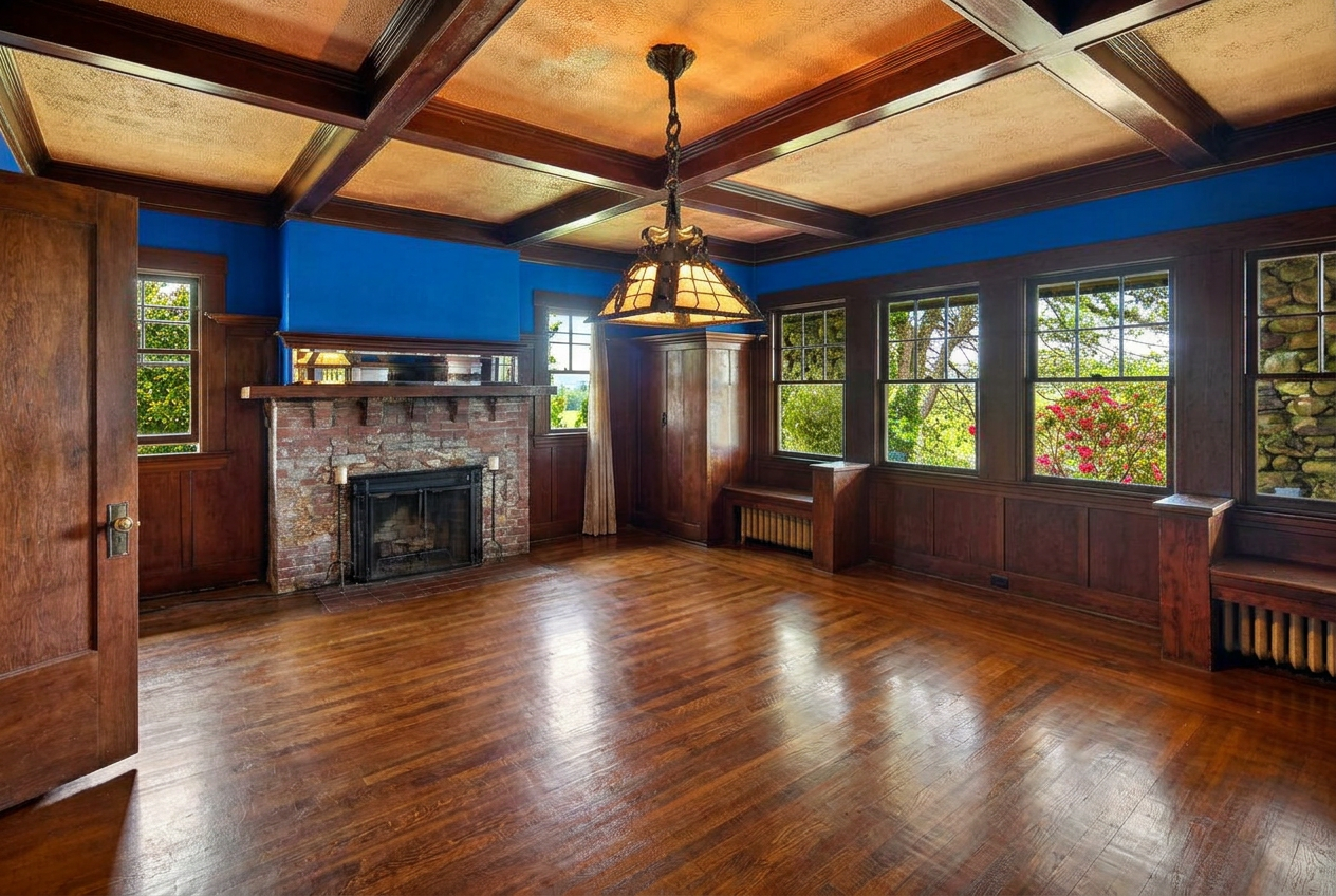 Dining room with coffered ceiling, panelled walls and a stone fireplace, shown vacant